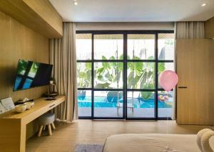 a bedroom with a bed and a desk and a window at Akaya Villas Solo in Kemiri