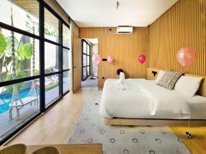 a bedroom with a bed and balloons on the wall at Akaya Villas Solo in Kemiri