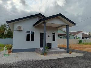 a small white house with a black roof at IRDINA GUESTHOUSE in Kuantan