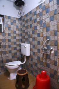 ハイデラバードにある8 MidTown-1BHK, Near AIG Hospital, Hitech Cityのタイル張りの壁、白いトイレ付きのバスルーム