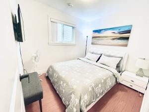 a white bedroom with a bed and a flat screen tv at Free Breakfast/Luxury/Modern/Vancouver & Burnaby in Vancouver