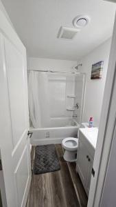 a white bathroom with a toilet and a sink at New Decently Furnished Suit in Regina