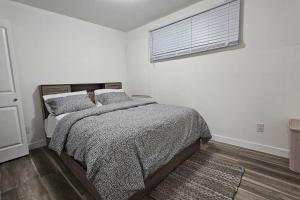a white bedroom with a bed and a window at New Decently Furnished Suit in Regina