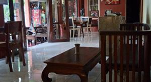 - une table et des chaises en bois dans un restaurant dans l'établissement Griya Istana 1, à Solo