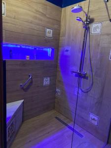 a bathroom with a shower with purple lights in it at Joli Duplex in Amilcar