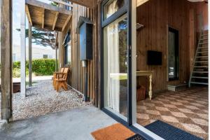 an open glass door of a house with a patio at Rustic Barn by the Bay in Low Head