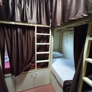 a dorm room with two bunk beds and a ladder at New Assar International dormitory in Mumbai