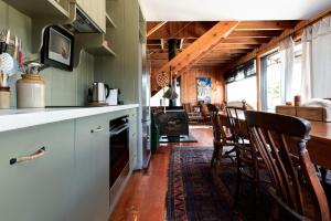 a kitchen with a counter and chairs in a room at Rustic Barn by the Bay in Low Head