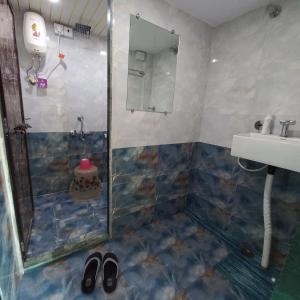 a bathroom with a shower and a sink at New Assar International dormitory in Mumbai