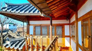 un porche de una casa con techo azul en Hanji Gguljam, en Jeonju