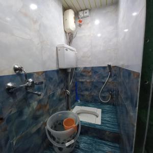 a small bathroom with a toilet and a shower at New Assar International dormitory in Mumbai