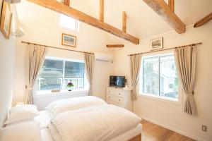two beds in a bedroom with a window at Snow Horizon in Hakuba