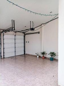an empty garage with white doors and potted plants at Casa Monserrat: Céntrica y Acogedora in Concepción