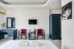 a bedroom with two red chairs and a desk at La Casona Boutique Hotel in Ho Chi Minh City