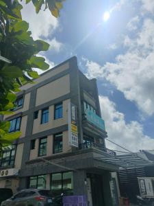 a building in a city with the sun in the sky at Yan Gui Lai B&B in Hengchun