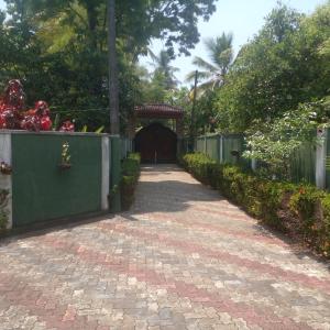 una pasarela de ladrillo que conduce a una puerta en un jardín en Paradise villa aluthgama en Aluthgama