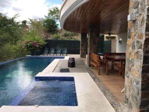 a pool with a table and chairs next to a house at Casa Monk in Nasugbu
