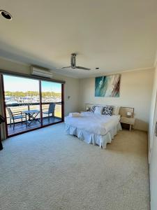 a large bedroom with a bed and a balcony at Mariners Cove at Paynesville in Paynesville