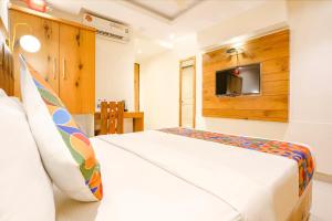ムンバイにあるFabHotel Anam Internationalのベッドルーム1室(ベッド1台、壁にテレビ付)