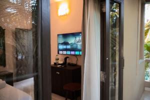 een kamer met een tv en een tafel en een raam bij La Ritz beach luxury hotel in Oud Goa