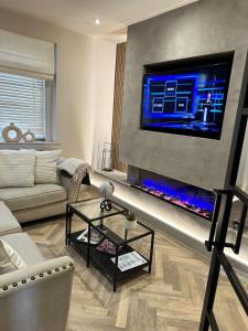 Μια τηλεόραση ή/και κέντρο ψυχαγωγίας στο Stunning Town Center Cottage with hot tub