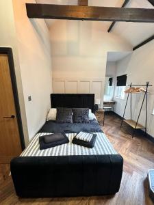 a bedroom with a large black bed in a room at Stunning Town Center Cottage with hot tub in Morpeth