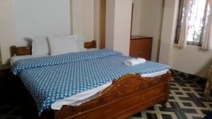 a bedroom with a bed with a blue comforter at HOTEL NIRALA , Darjeeling in Darjeeling