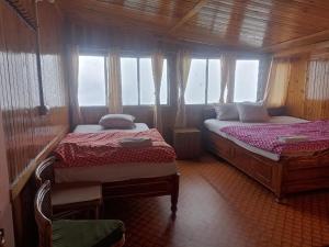 - une chambre avec 2 lits et une fenêtre dans l'établissement HOTEL NIRALA , Darjeeling, à Darjeeling