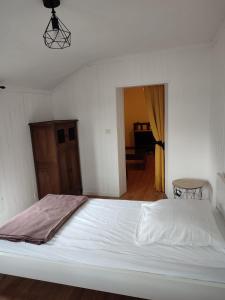 1 cama blanca en un dormitorio con 1 habitación en Location petite maison en Quillebeuf-sur-Seine