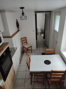 a dining room with a white table and chairs at Location petite maison in Quillebeuf-sur-Seine