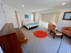 1 dormitorio con cama, sofá y mesa en Beachside Bliss en Tauranga