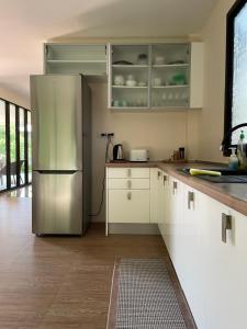 a kitchen with white cabinets and a stainless steel refrigerator at SEASUN Villa Haad Tien in Haad Tian