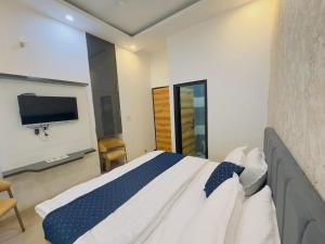 ZirakpurにあるAa Hotels & Resorts Chandigarh Zirakpurのベッドルーム1室(ベッド1台、壁掛けテレビ付)
