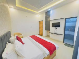 een slaapkamer met een groot bed en een televisie bij Aa Hotels & Resorts Chandigarh Zirakpur in Zirakpur
