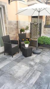 um pátio exterior com cadeiras e um guarda-sol em Casetta Nilu' em Procida