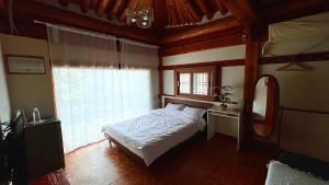 a bedroom with a bed and a large window at Hanji Gguljam in Jeonju