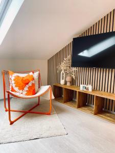 uma sala de estar com uma cadeira e uma televisão em Hotel-Bistro-Europa em Merchweiler