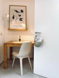 einen Schreibtisch mit einem weißen Stuhl neben einem Tisch in der Unterkunft Hotel-Bistro-Europa in Merchweiler