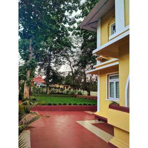 una casa con una pasarela de ladrillo rojo junto a un edificio en OYO Shooolin Homestay, en Goa