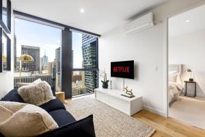 1 dormitorio con cama y ventana grande en Luxuria Apartments - Collins House en Melbourne