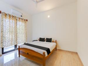 een slaapkamer met een bed en een raam bij Collection O Continental Bay Inn in Chennai