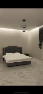 um quarto branco com uma cama com cabeceira de cama em سي بريز em Quţuf al Mişrī