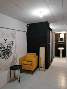 チェンマイにあるLita Guesthouseの椅子と蝶が壁に掛けられた部屋