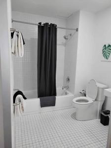 a bathroom with a toilet and a black shower curtain at 629 Lofts 810 - A KCM Property in Cleveland