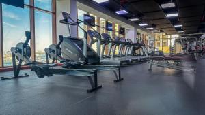 een fitnessruimte met rijen loopbanden en ramen bij Luxury Studio at Palm Jumeirah in Dubai