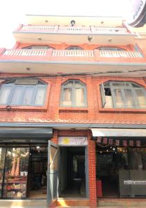 Un frente de tienda de un edificio de ladrillo con ventanas en 21 Tara Apartments, en Katmandú