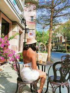 una mujer con un vestido blanco sentada en una silla en Sunset Hotel Phu Quoc - welcome to a mixing world of friends en Phu Quoc