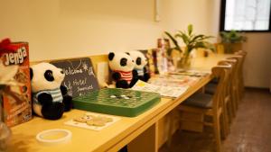 two stuffed panda bears sitting on a table with a laptop at Hotel Sanrriott Osaka Hommachi in Osaka