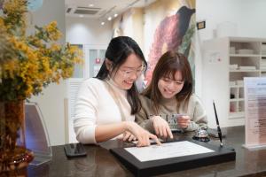 two women looking at a piece of paper on a table at Hotel Sanrriott Osaka Hommachi in Osaka