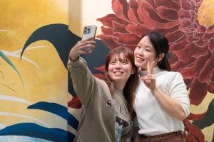 two women taking a picture with a cell phone at Hotel Sanrriott Osaka Hommachi in Osaka